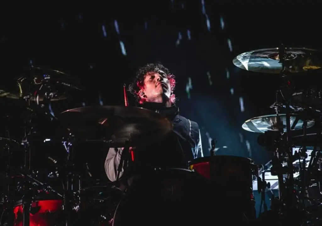 Foco em Josh tocando bateria em meio ao instrumento
